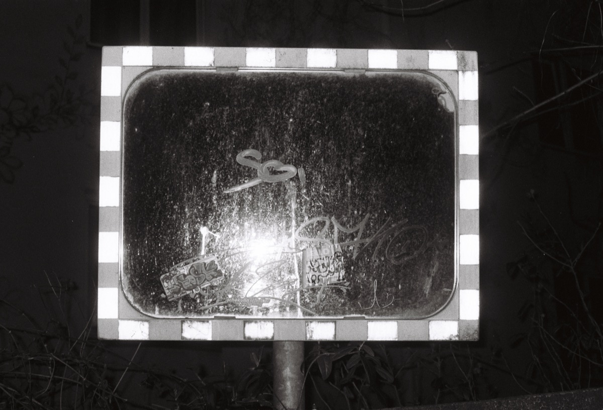 A traffic mirror at night, black and white
