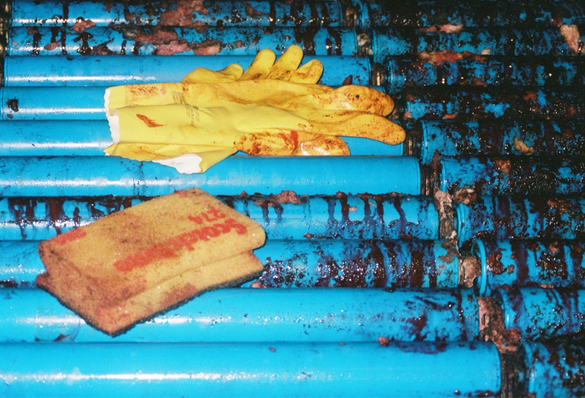 Yellow work gloves on a blue metal surface
