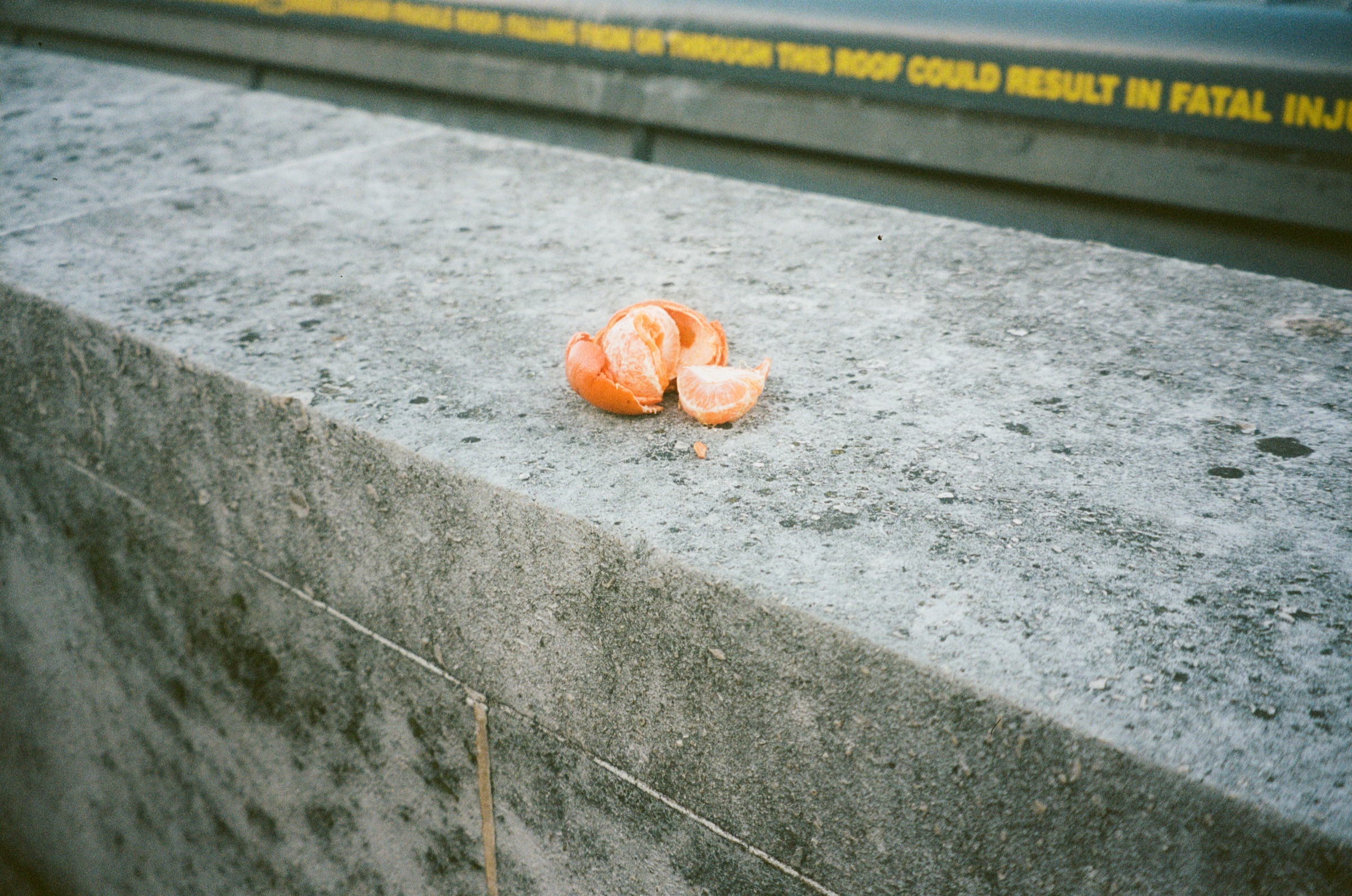 A peeled orange on a concrete ledge