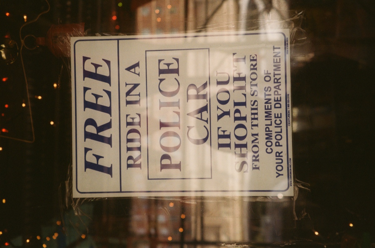Shop sign offering a free ride in a police car to shoplifters